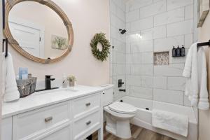a white bathroom with a sink toilet and a mirror at 3b/3b River Townhome A for 6, Steps Gruene Hall in Gruene +71 photos