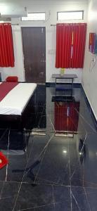 a bedroom with a bed and a table and red curtains at Grandview mansion & Daulat villas in Udaipur