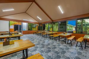 a restaurant with tables and chairs and windows at Tam Coc Forest Bungalow & Spa in Ninh Binh