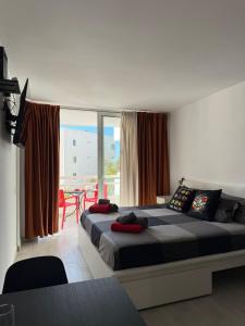 Un dormitorio con una cama grande y una mesa con sillas. en RUBIK's studio, lovely Las Americas, en Costa de Adeje