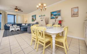 a dining room and living room with a table and chairs at Phoenix VI 61408 in Orange Beach