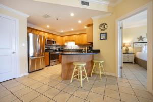 a kitchen with a counter and two stools at Phoenix VI 61408 in Orange Beach