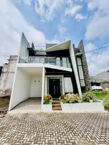 a large white house with a balcony on top at Arrayyan Executive Village Kota Batu in Batu +67 photos