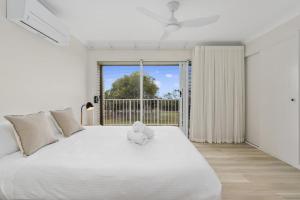 Un osito de peluche sentado en una cama en un dormitorio. en Woorim Beach Sunrise, en Woorim