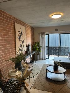 ein Wohnzimmer mit einer Couch und einer Ziegelwand in der Unterkunft The luxury IN waterfall Midrand in Midrand