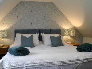 una camera da letto con un letto con due cuscini sopra di Clachries Cottage a Boreland of Colvend