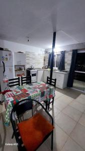 a kitchen with a table and two chairs and a table and a kitchen with at La Loma del Valle in Tanti +12 photos