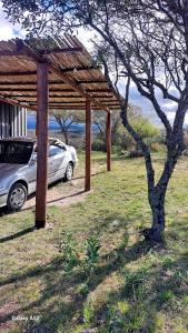a car parked under a wooden pavilion in a field at La Loma del Valle in Tanti