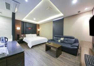 um quarto de hotel com uma cama e um sofá em Arieti A em Gimhae