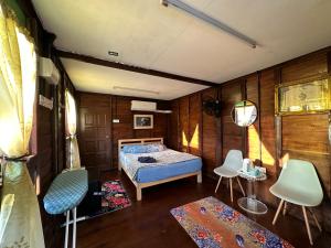 a bedroom with a bed and chairs in it at Homestay Singgah Keluarga Warisan Abg Tam in Kepala Batas +15 photos