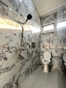 a bathroom with a shower and a toilet at Arrayyan Executive Village Kota Batu in Batu