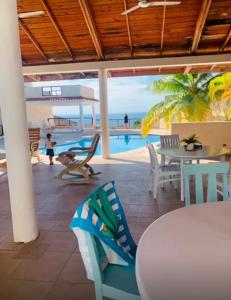 Un patio con mesa y sillas y una piscina. en Costa del mare paradiso, 