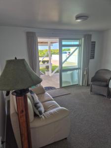 a living room with a couch and a lamp at Bronny's Beachfront BnB in Whitianga