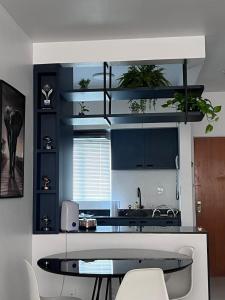 a kitchen with a table and some plants on the shelves at Belo Apartmento Bosque da Saúde in Cuiabá +19 photos