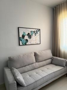a living room with a couch and a picture on the wall at Belo Apartmento Bosque da Saúde in Cuiabá