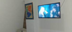a flat screen tv hanging on a wall with two paintings at Tesoro Palmas Resort in Mazatlán
