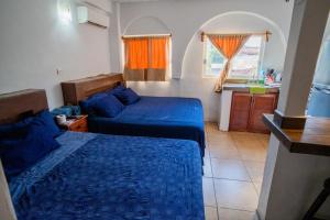 ein kleines Zimmer mit 2 Betten und einer Küche in der Unterkunft Hotel Casa Boquita Estudios equipados con alberca y jacuzzi in Zihuatanejo + 180 Fotos