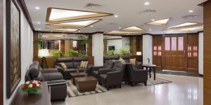 a waiting room with couches and chairs in a lobby at Keys Select by Lemon Tree Hotels, Malabar Gate, Kozhikode in Kozhikode