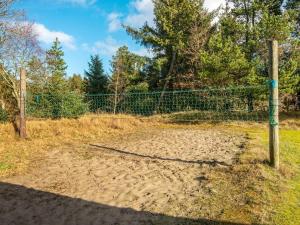 a fence in front of a field with trees at 18 person holiday home in Rømø in Kongsmark