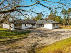 a white house with a large driveway at 18 person holiday home in Rømø in Kongsmark