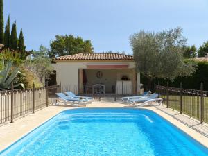 a swimming pool with chairs and a house at Villa Jasmin Regusse in Régusse