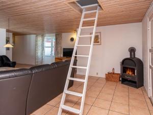 a ladder in a living room with a fireplace at 18 person holiday home in Rømø-By Traum in Kongsmark