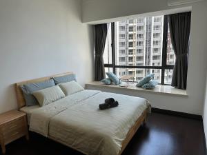 a bedroom with a bed with a pair of shoes on it at Mahogany Homes at R&F - free WiFi and 1 Car Park in Johor Bahru
