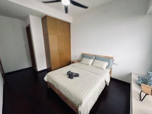 a bedroom with a bed with a black bag on it at Mahogany Homes at R&F - free WiFi and 1 Car Park in Johor Bahru +17 photos