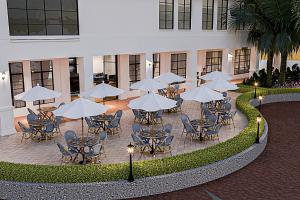 a group of tables and chairs with umbrellas in a courtyard at The Lisbon Melaka, Trademark Collection by Wyndham in Melaka