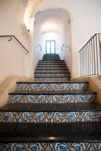 a row of stairs leading up to a stair case at Palazzo Conti Camere & Suites in Scicli
