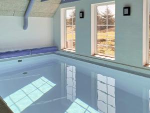 a swimming pool in a house with two windows at 12 person holiday home in Ringkøbing-By Traum in Søndervig +53 photos