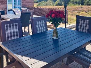 a vase of roses sitting on a wooden table at 12 person holiday home in Ringkøbing-By Traum in Søndervig