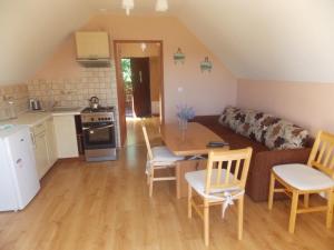 a kitchen and a living room with a table and chairs at Mazury Home in Giżycko