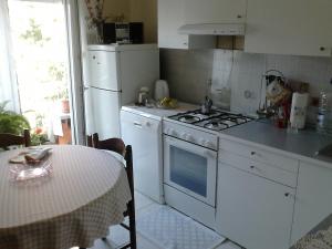 a kitchen with a white stove and a table with a table cloth at Apartment Dragan in Pula