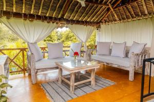 a living room with two chairs and a table at Seb Villa in Diani Beach
