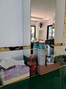 a table with a basket of plates and dishes at Cocoloco hostel in Ban Khlong Haeng