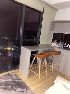 eine Küche mit zwei Hockern und einer Theke mit einem Fenster in der Unterkunft Căn hộ 1 phòng ngủ Wyndham Lynn Times Thanh Thủy in Phú Thọ + 9 Fotos