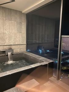 ein Badezimmer mit einer Badewanne und einem Brunnen in der Unterkunft Căn hộ 1 phòng ngủ Wyndham Lynn Times Thanh Thủy in Phú Thọ