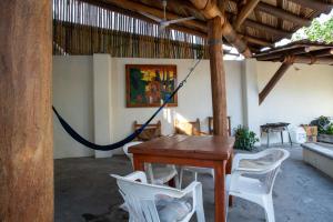 ein Esszimmer mit einem Holztisch und weißen Stühlen in der Unterkunft Hotel Casa Boquita Estudios equipados con alberca y jacuzzi in Zihuatanejo