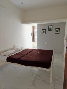 a bedroom with a large bed with a brown blanket at AVANI Stays in Yelagiri