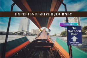 a boat in the water with a sign that reads experience river journey at Belivin'98 Sense of Pier Sathorn Residence in Bangkok