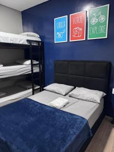 a bedroom with two bunk beds and a blue wall at On Park Hotel e Traslado in Guarulhos