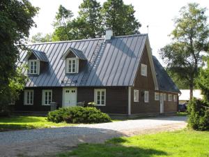 a barn with a metal roof on a house at Mandjala Puhketalu - Cottages in Mändjala