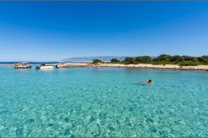 eine Person, die in einem großen Wasserkörper schwimmt in der Unterkunft Guesthouse Gligora in Mandre