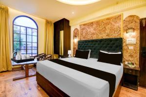a hotel room with a large bed and a desk at Super Townhouse Varanasi Railway Junction in Varanasi +22 photos