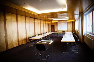 a conference room with tables and chairs and a whiteboard at Rheinhessen Inn GmbH in Wörrstadt