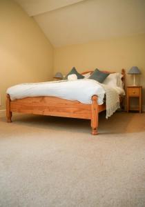 - une chambre dotée d'un lit en bois avec des draps et des oreillers blancs dans l'établissement 3 Prospect Place, New Quay, sleeps 6, parking, sea views, dog friendly, à New Quay