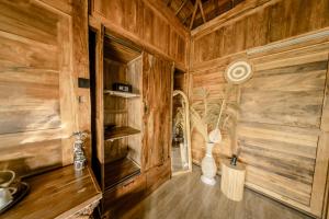 a kitchen with wooden walls and wooden flooring at Sunsura Villas in Nusa Penida +18 photos