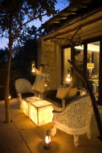 a person standing on a patio at night with lights at Pashan Garh Panna National Park - A Taj Safari Lodge in Panna