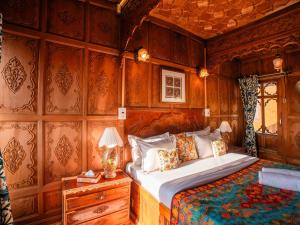 a bedroom with a bed and a wooden wall at Moustache Houseboat Srinagar in Srinagar +29 photos
